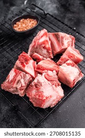 Raw lamb mutton meat and bones for stew or goulash. black background. top view.