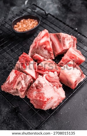 Raw lamb mutton meat and bones for stew or goulash. black background. top view.