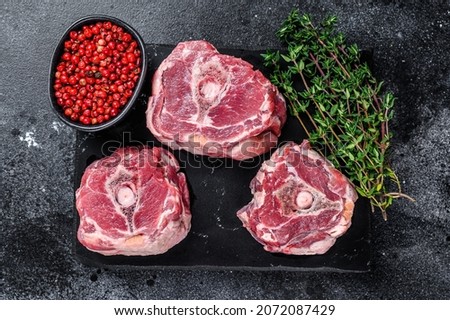 Raw lamb neck meat on a marble board..Black background. Top view
