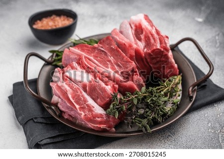 Raw lamb Riblets, fresh mutton meat with rib bone. grey background. top view.