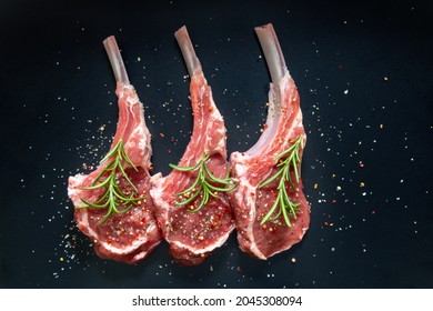 raw lamb saddle meat on bone with salt, pepper decorated rosemary top view on black background - Powered by Shutterstock