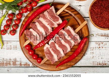 Raw lamb tenderloin on wood background. Raw lamb tenderloin with herbs and spices. Top view