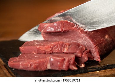 Raw Lean Meat Being Cut By Chefs Knife Shot In Landscape Mode