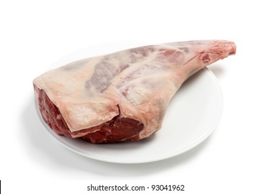 A Raw Leg Of Lamb Against A White Background