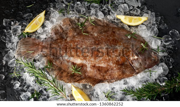 Raw\
lemon sole fish on ice with herbs and lemon\
wedges.