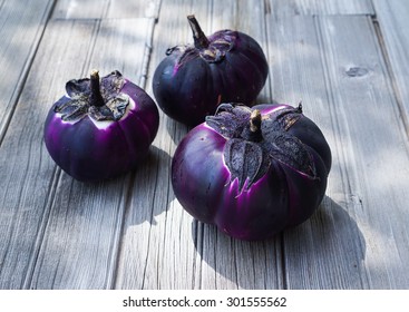 Raw Local Heirloom Barbarella Aubergines Or Eggplants On Wooden Background, Selective Focus.