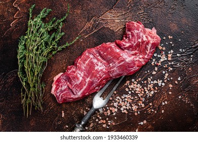 Raw Machete Skirt Beef Steak On Meat Fork. Dark Background. Top View