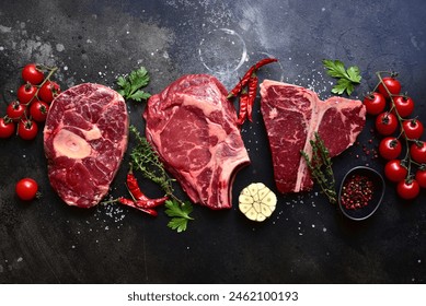 Raw marbled beef steaks   on a dark slate, stone or concrete background . Top view with copy space. - Powered by Shutterstock