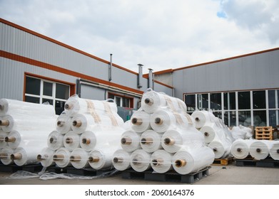 Raw materials warehouse. Many large coils of finished propylene hose made of woven thread for making industrial bags. Polypropylene rolls for packaging.