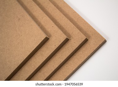 Raw MDF boards, brown in color. They are made of chopped wood.
