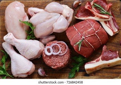 Raw Meat Assortment - Beef, Lamb, Chicken On A Wooden Board