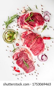 Raw meat, beef steak on cutting board with rosemary and spices, white background, top view copy space - Shutterstock ID 1753069463