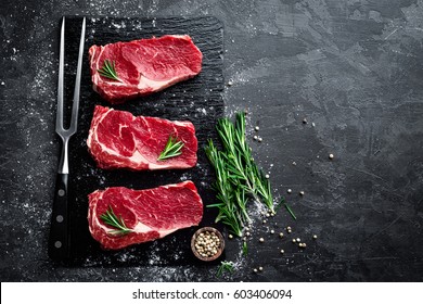 Raw meat, beef steak on black background, top view - Shutterstock ID 603406094