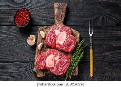 Raw meat osso buco veal shank steak , making italian ossobuco. Black Wooden background. Top view