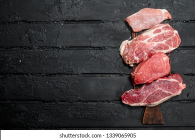 Raw meat pork and beef steaks. On a black rustic background. - Shutterstock ID 1339065905