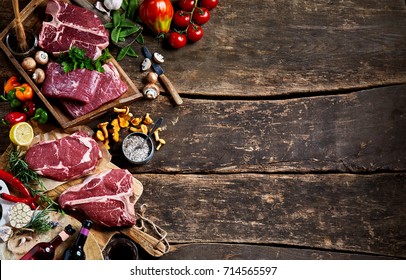 Raw Meat, Wine, Ingredients And Fresh Produce On A Rustic Timber Bench Top With Copy Space.