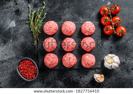 Raw meatballs made from ground beef. Black background. Top view