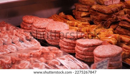 Raw minced meat beef burger cutlets in a window shop. Beef burgers and other meat preps ready to be sold. Food industry.