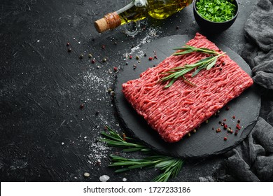 Raw minced meat on a black surface. Top view. Free space for your text.