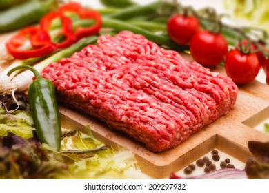  raw minced meat with vegetables on wooden board, selective focus