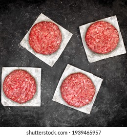 Raw Minced Steak Burgers From Beef And Pork Meat On Black Background, Overhead View. Raw Ground Beef, Round Patties For Cooking Homemade Burger On BBQ Grill, Top View