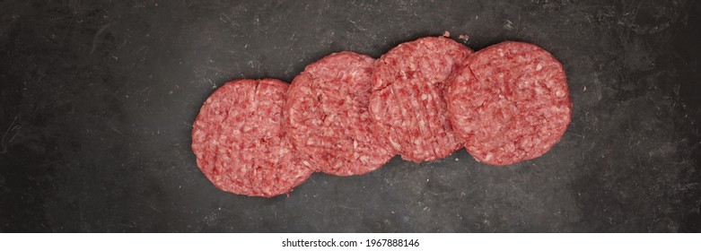 Raw Minced Steak Burgers From Beef And Pork Meat On Black Background, Overhead View. Raw Ground Beef, Round Patties For Cooking Homemade Burger On BBQ Grill, Top View