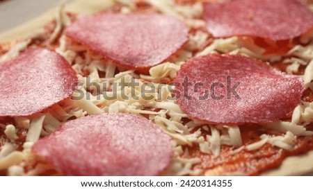 Raw Mushrooms with Salami and Cheese on Pizza Dough. Close-up, shallow dof.