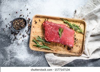 Raw New York Strip Steak On A Wooden Tray. Beef Meat. Gray Background. Top View