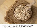 Raw oatmeal porridge in neutral beige background copy space. Whole spelt grain species. High protein fiber-rich vegan plant based food ingredient. Gluten free superfood healthy nutritional dietary