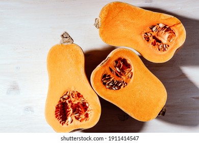 Raw Organic Butternut Squash Ready To Cook On White Wooden Background Viewed From Above, Plant Based Food, Harsh Shadows