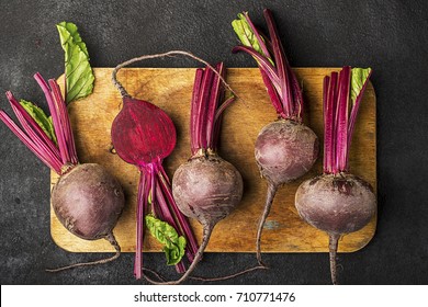 Raw Organic Farm Beetroot On A Vintage Wooden Cutting Board On A Plain Black Background. Top View.