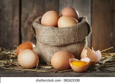 Raw organic farm eggs, straw on the old wooden background
