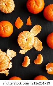 Raw Organic Mandarin Oranges On A Black Surface, Top View. Flat Lay, Overhead, From Above. 