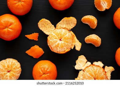 Raw Organic Mandarin Oranges On A Black Background, Top View. Flat Lay, Overhead, From Above.