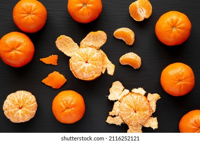 Raw Organic Mandarin Oranges On A Black Surface, Top View. Flat Lay, Overhead, From Above.