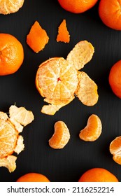 Raw Organic Mandarin Oranges On A Black Surface, Top View. Flat Lay, Overhead, From Above.