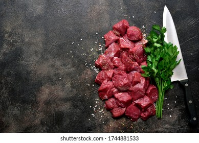 Raw Organic Meat ( Beef Or Lamb ) On A Dark Slate, Metal, Stone Or Concrete Background. Top View With Copy Space.