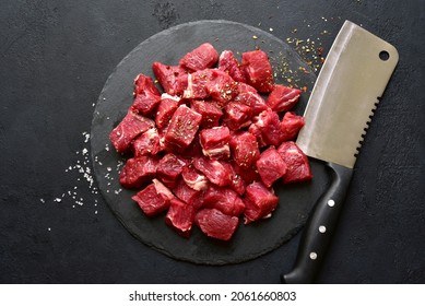 Raw organic meat ( beef or lamb ) on a black slate board. Top view with copy space. - Shutterstock ID 2061660803