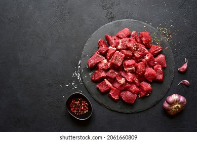 Raw organic meat ( beef or lamb ) on a black slate board. Top view with copy space. - Shutterstock ID 2061660809