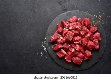 Raw organic meat ( beef or lamb ) on a black slate board. Top view with copy space. - Shutterstock ID 2061660815
