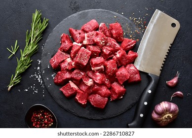 Raw organic meat ( beef or lamb ) on a black slate board. Top view with copy space. - Shutterstock ID 2286710827