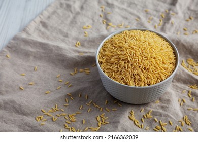 Raw Organic Risoni Pasta In A Bowl, Side View. Copy Space.