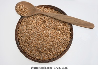 Raw organic spelt or dinkel wheat or hulled wheat (Triticum spelta) in a wooden bowl