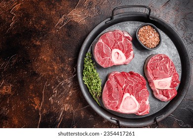 Raw Osso buco Veal shank steak, meat Ossobuco in steel tray. Dark background. Top view. Copy space. - Powered by Shutterstock