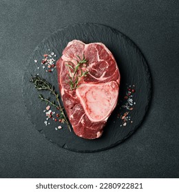 Raw ossobuco steak with rosemary on a black slate plate. Free space for the recipe. - Powered by Shutterstock