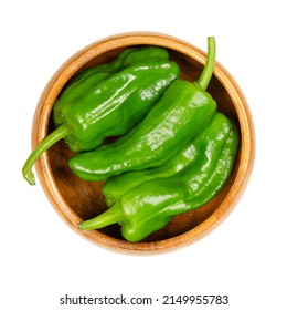 Raw Padron peppers, also called Herbon peppers, in a wooden bowl. Variety of Capsicum annuum from the municipality of Padron in northwestern Spain. Small, green and mild peppers with elongated shape.