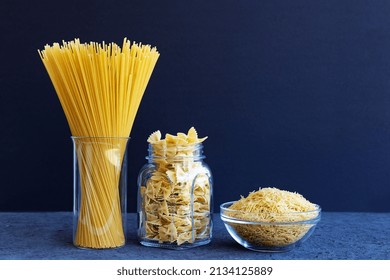 Raw pasta. Glass jar filled with various spaghetti, farfalle, noodles on a dark blue background. - Powered by Shutterstock