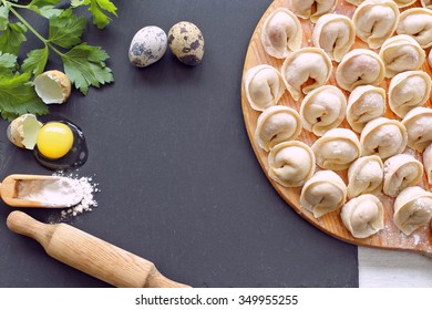 Raw Pelmeni On Black Stone Desk With Eggs, Parsley, Rolling 