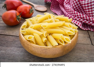 Raw Penne Pasta In Wooden Bowl