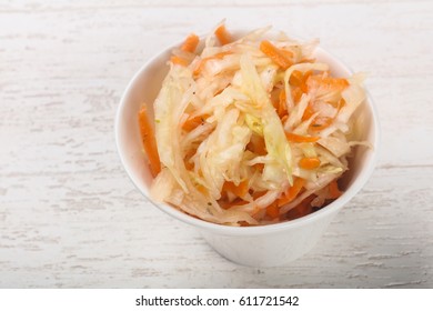 Raw pickled cabbage on wood background